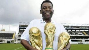 Pelé posa con tres copas del Mundial