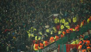 Seguidores del Betis se enfrentan a la policía durante un partido ante el Manchester United en Old Trafford, el jueves 9 de marzo de 2023 (AP Foto/Dave Thompson)