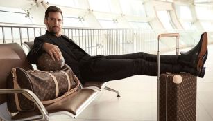 Lionel Messi posando con los pies sobre una maleta Louis Vuitton