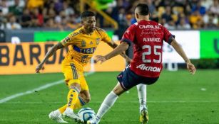 Aquino y Alvarado luchan por la pelota en el Tigres vs Chivas