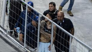 El defensor siendo escoltado al salir de la cancha del Estadio Azteca