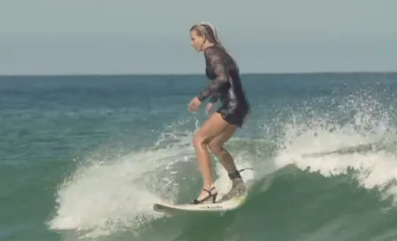 Mujer surfea con tacones y vestido