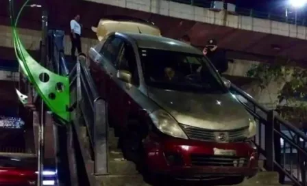 Taxi en Naucalpan intenta cruzar puente peatonal y se queda atascado