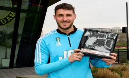 Santiago Giménez recibe premio al jugador del mes y rompe el trofeo