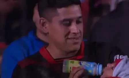 Aficionado argentino fue captado dándole biberón a su bebé en partido y es nominado a The Best