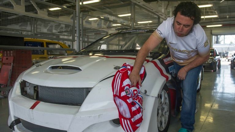 Micky Huidobro limpia un auto con la camiseta de Chivas