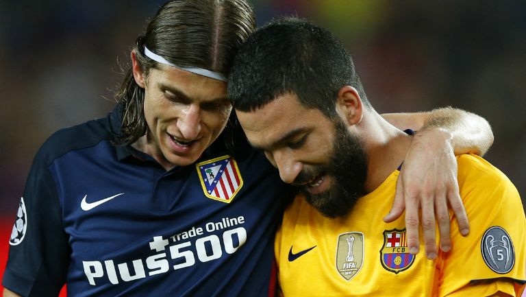 Filipe Luis y Arda Turan durante el duelo de Champions League