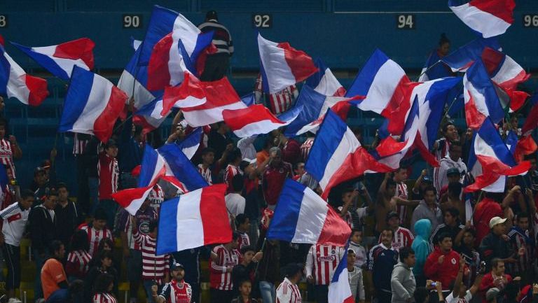 Aficionados de Chivas con banderas en tribunas