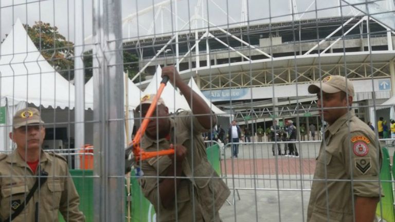 Los bomberos tratando de romper el candado de una puerta del estadio Olímpico