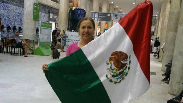 Evelia Macedo sostiene una bandera de México en apoyo a su hijo