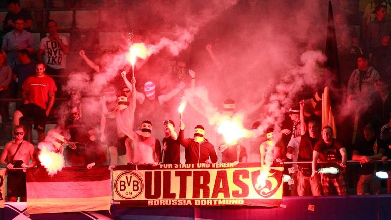 Ultras del Dortmund portan bengalas en las gradas