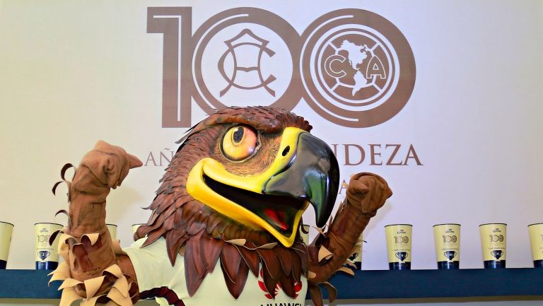 La mascota de las Águilas frente al logo de los 100 años de América