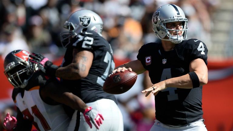 Derek Carr observa a sus receptores antes de lanzar 