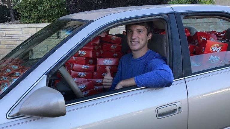 Hunter Hobbin en su vehículo el cual fue llenado de chocolates por la empresa Kit Kat