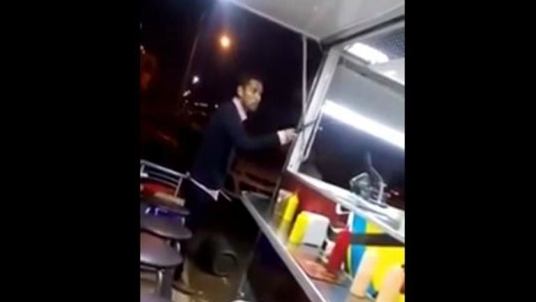 Momento en que el hombre amenaza al vendedor de hamburguesas