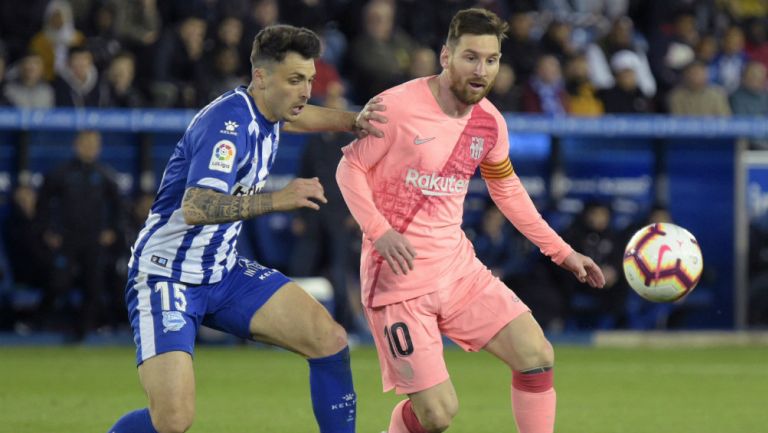 Messi intenta quedarse con el balón ante la persecución de un defensa