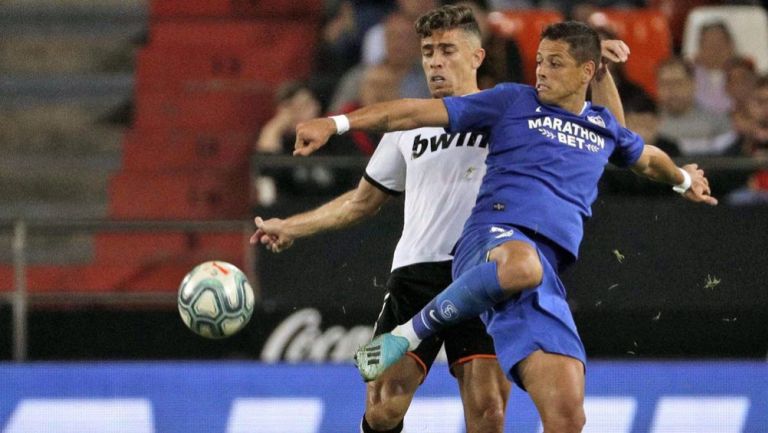 Chicharito disputa un balón con Gabriel Paulista