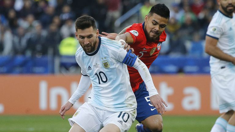 Messi disputa el balón en partido contra Chile