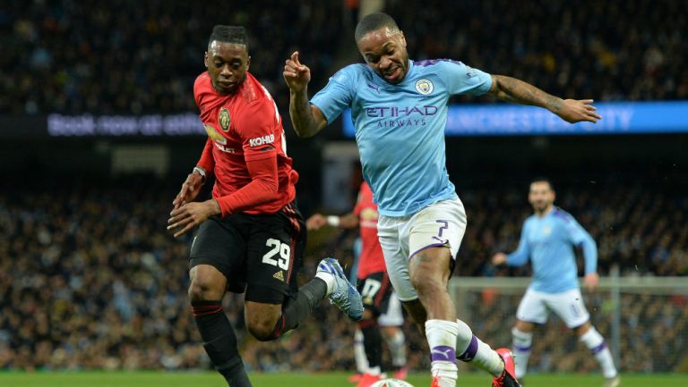 Jugadores del Manchester City y Manchester United disputan la bola