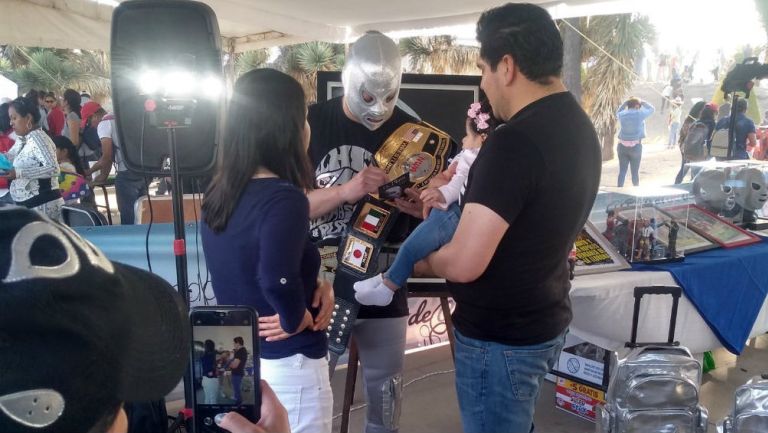 Imitador del Hijo del Santo firmando a fanáticos