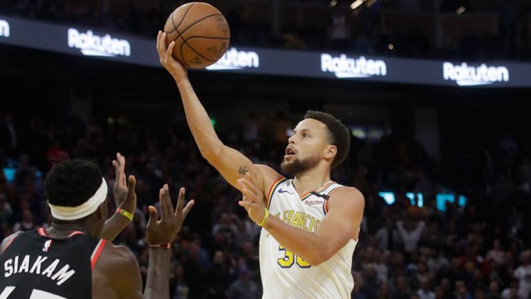 Stephen Curry intenta anotar ante Raptors 