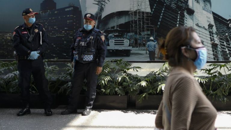 Policías y mujer con cubrebocas en la CDMX