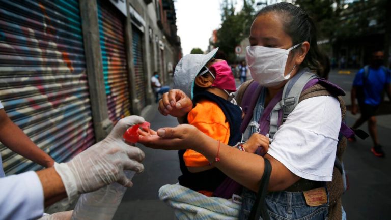 Mujer toma gel antibacterial en la CDMX