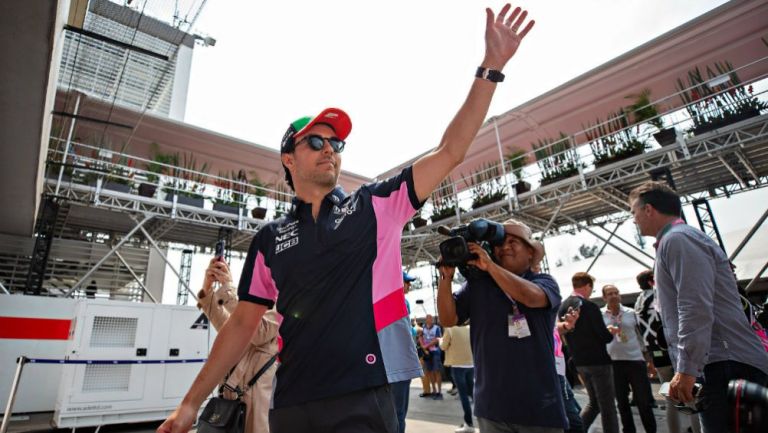 Checo Pérez saludando durante un evento