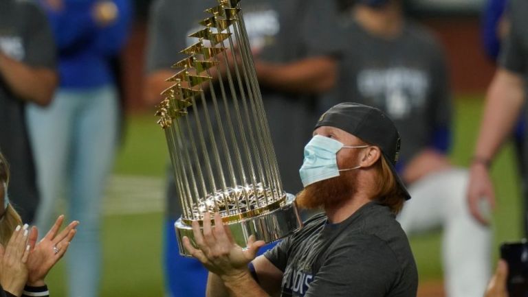 Justin Turner cargando el trofeo de la MLB