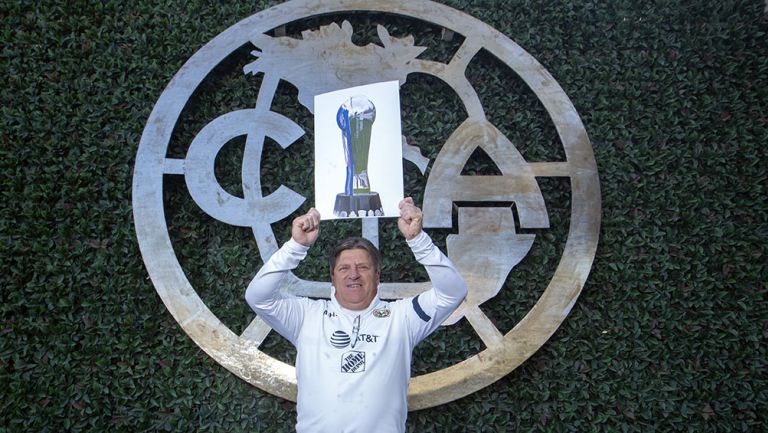 Piojo Herrera sostiene una imagen con el trofeo de Liga MX