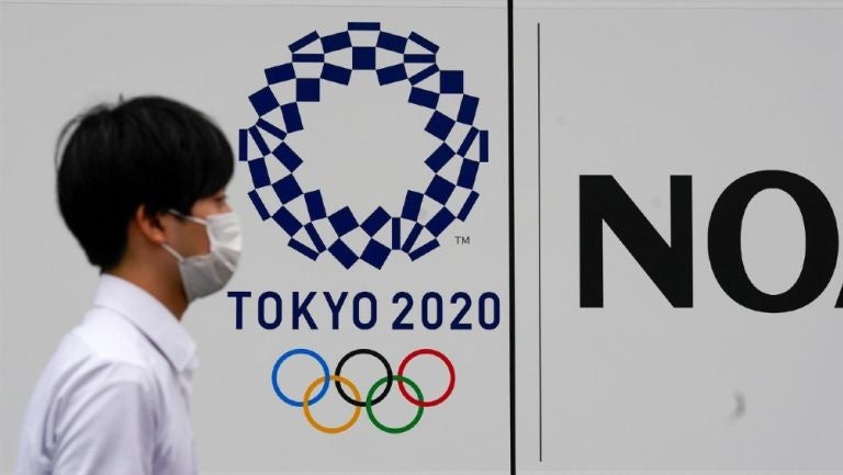 Peatón junto a logo de los Juegos Olímpicos Tokio 2020