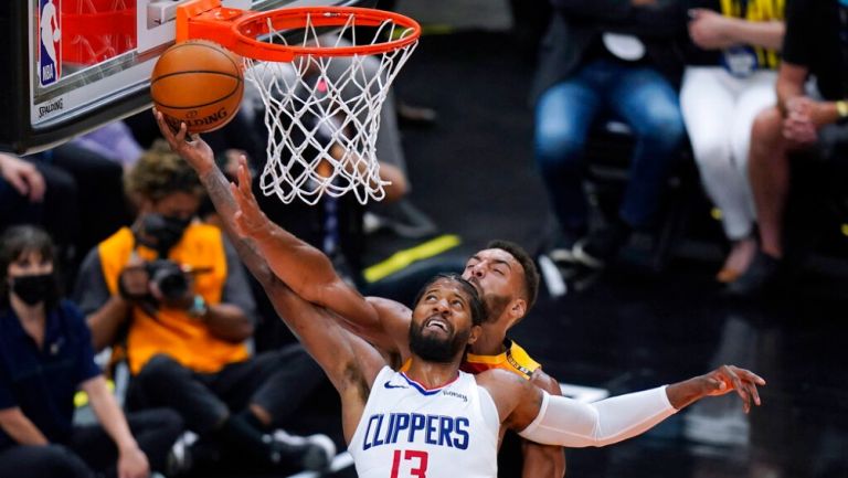 Paul George de los Clippers intenta encestar sobre el pívot Rudy Gobert de los Jazz