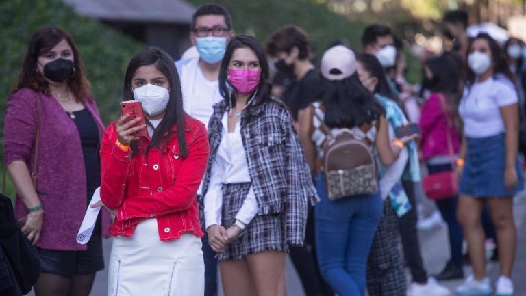 Jóvenes con cubrebocas esperan entrar a concierto al Auditorio Nacional