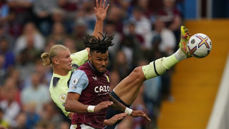 Erling Haaland y Tyrone Mings en disputa por el balón