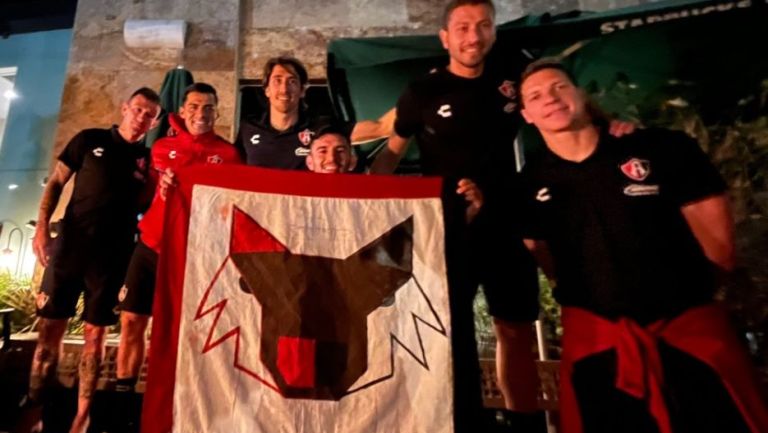 Jugadores del Atlas afuera del hotel con una bandera que llevaron los seguidores